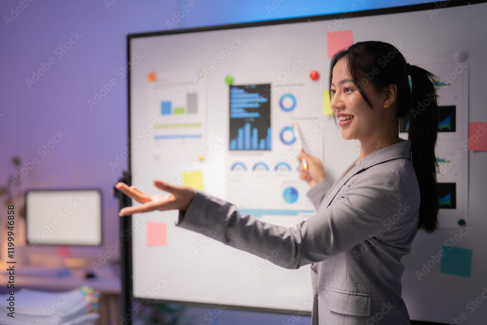 Asian businesswoman is using a whiteboard, marker, charts and graphs to explain positive results of a project during a presentation in a modern office Asian businesswoman is using a whiteboard, marker, charts and graphs to explain positive results of a project during a presentation in a modern office