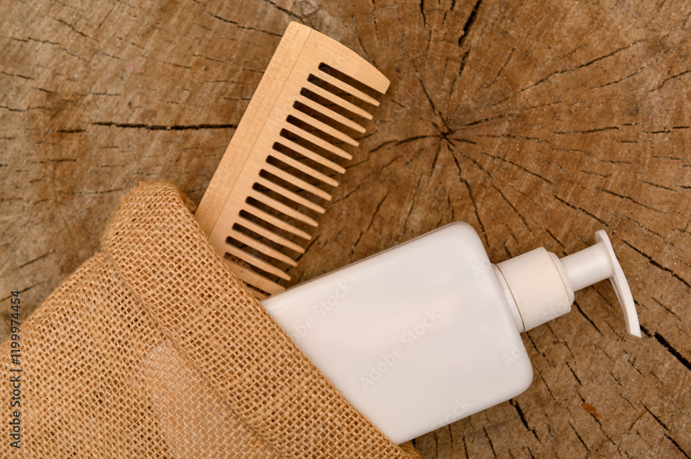 Obraz premium White plastic container with dispenser and wooden comb in a canvas bag.