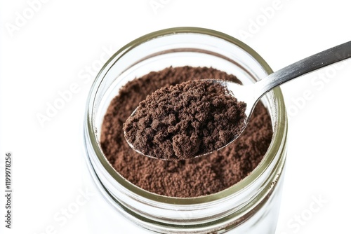 A spoon with a generous amount of cocoa powder on a jar, perfect for baking or cooking photo