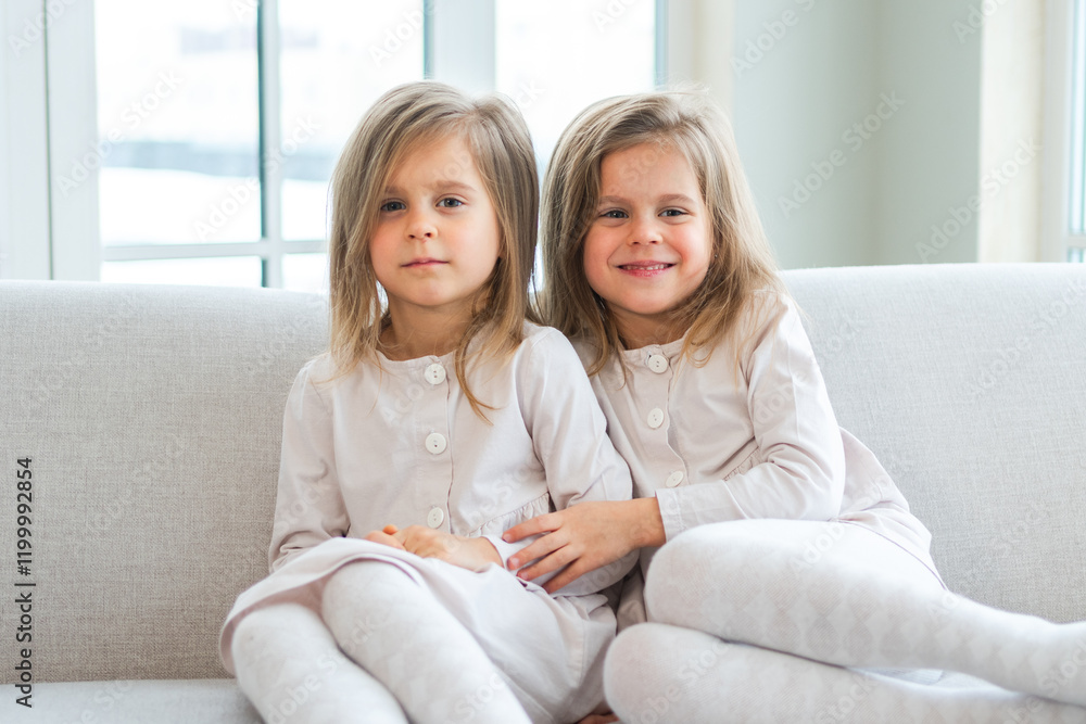 Happy family sisterly love. Two funny little twin sisters girls hugging with love care playing together at home indoors. Happy children lifestyle. Identical twin girls hugs. Girls friendship and youth Happy family sisterly love. Two funny little twin sisters girls hugging with love care playing together at home indoors. Happy children lifestyle. Identical twin girls hugs. Girls friendship and youth