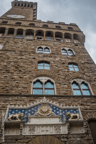 Perspective of facade of the Vecchio palace with Arnolfo clock tower and frontispiece in entrance portal, Florence ITALY photo