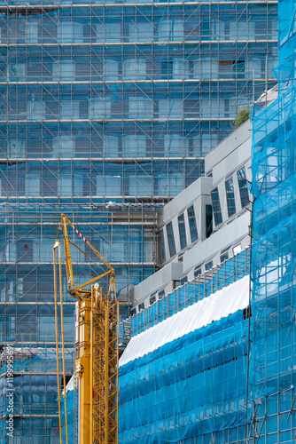 A construction site showcasing scaffolding and heavy machinery, emphasizing the process of urban development and the transformation of architectural spaces. photo