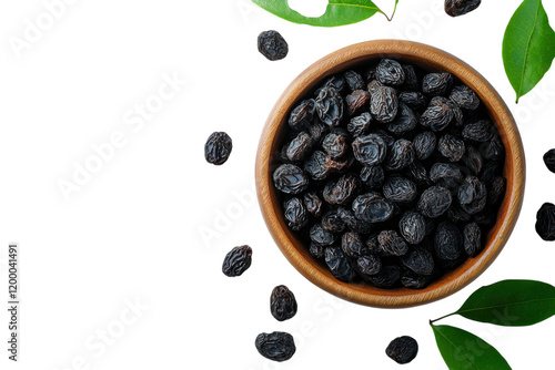 Dried black berries in a wooden bowl garnished with fresh green leaves on a light background