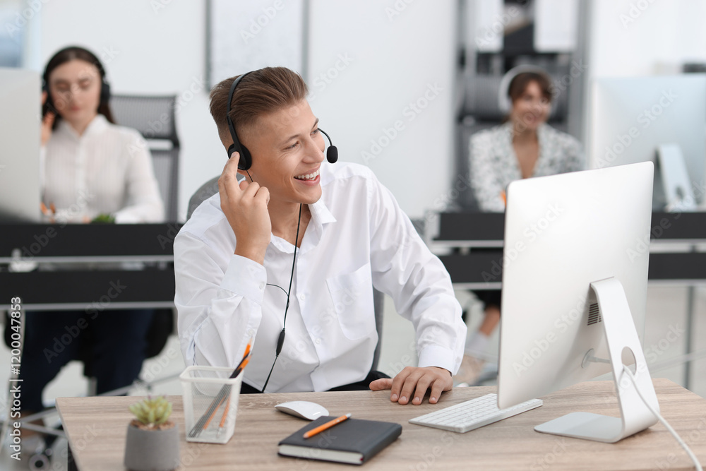 Salesman talking to client via headset at desk in office Salesman talking to client via headset at desk in office