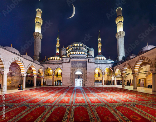 A grand Ottoman mosque dominates the skyline, its minarets reaching for the star-studded sky. The soft glow of the city lights reflects on the mosque's marble façade Generated image