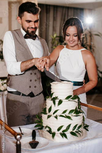 newlyweds happily cut and taste the wedding cake