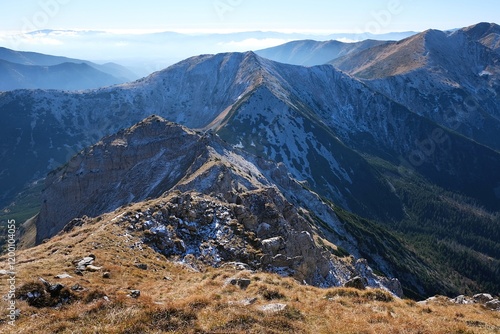 Panorama of Czerwone Wierchy range from around Kasprowy Wierch Peak, Tatras Mountains, Poland. During trekking red trail on sunny autumn day. Little silhouettes of people on trail.
