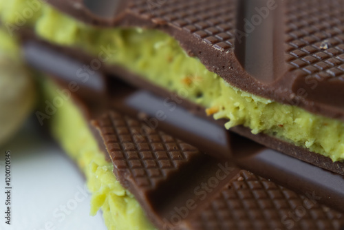 A chocolate bar with a vibrant pistachio filling in a green color — Dubai chocolate in every detail. The texture of Dubai chocolate looks like it melts in your mouth. Macro shot. photo