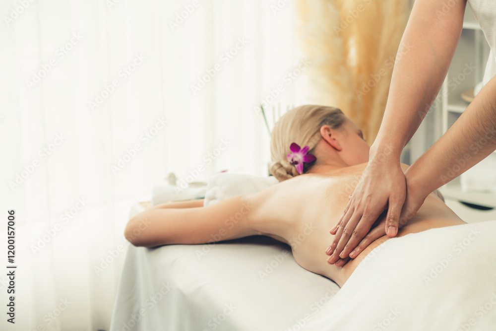 Obraz premium Caucasian woman customer enjoying relaxing anti-stress spa massage and pampering with beauty skin recreation leisure in day light ambient salon spa at luxury resort or hotel. Quiescent