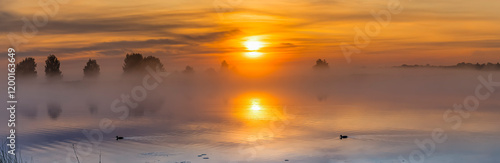 Sunrise over the river or lake. Morning fog and reflections above a water.  D...