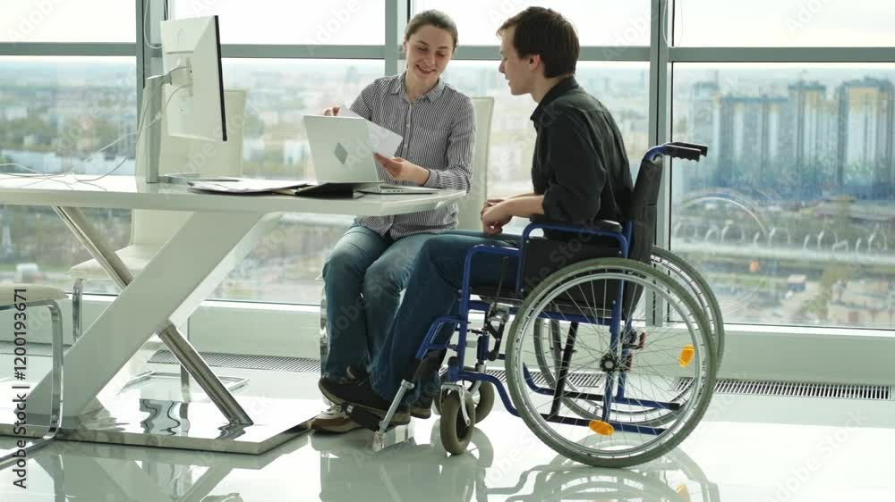 Colleagues business people woman man in chair for people with disability working on office. Startup business group team working together. Corporate professional team discussing project ideas Colleagues business people woman man in chair for people with disability working on office. Startup business group team working together. Corporate professional team discussing project ideas