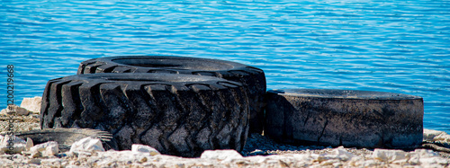 Abandoned tires on the side next to the lake