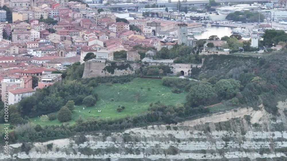 A video highlighting the dramatic cliffs of Ancona, covered in greenery, with historic buildings, a lighthouse, and the harbor in the background, showcasing the area's unique blend of nature and archi A video highlighting the dramatic cliffs of Ancona, covered in greenery, with historic buildings, a lighthouse, and the harbor in the background, showcasing the area's unique blend of nature and archi