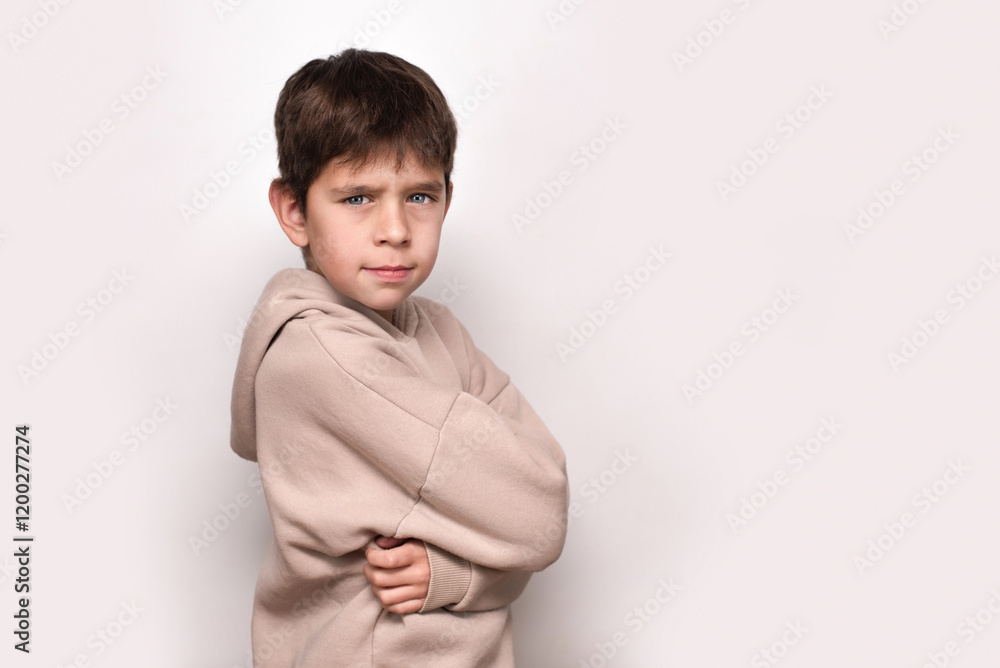 Confident young boy standing with crossed arms in a casual hoodie