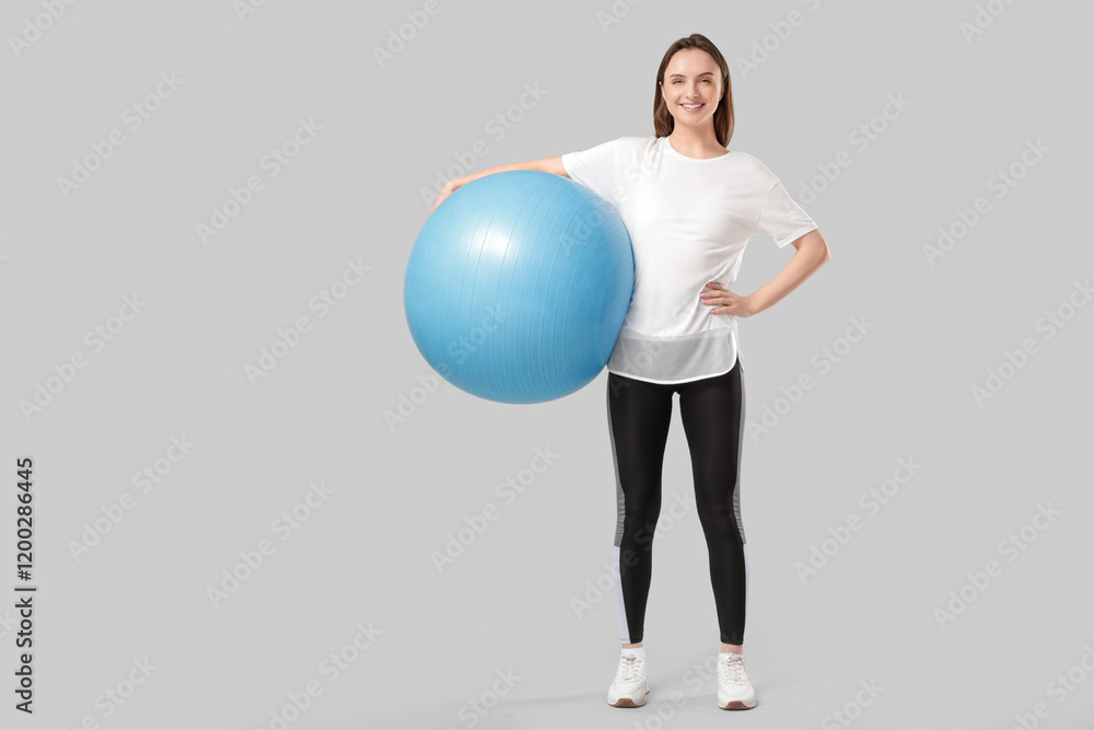 Sporty young woman with fitball on grey background Sporty young woman with fitball on grey background
