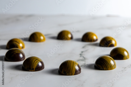 Cioccolatini assortiti di pasticceria in forme geometriche su marmo bianco come sfondo photo