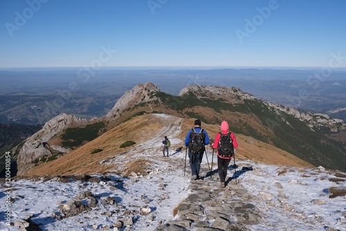 Scenery of autumn Tatras Mountains with silhouettes of hiking people. Giewont Peak on background. Czerwone Wierchy range from around Kasprowy Wierch Peak, Tatras Mountains, Poland.  
