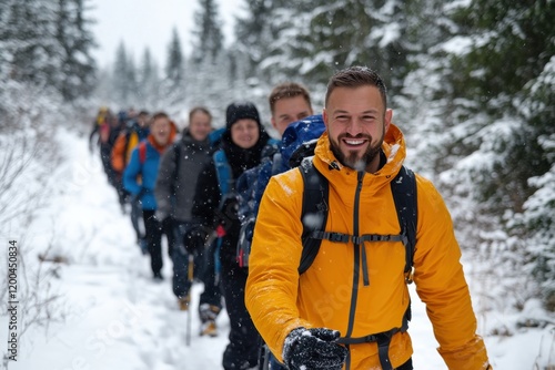 A content hiker wearing a bright yellow jacket and a navy beanie, enjoying the breathtaking views while resting on a snowy mountain peak under a clear blue sky. photo