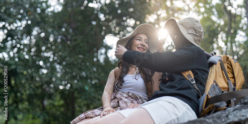 LGBT couple sharing a tender moment while hiking in a sunlit forest photo