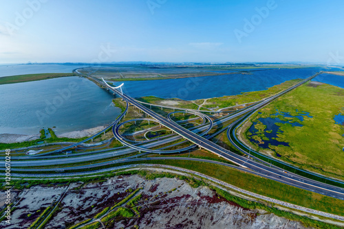 Shinpo-ri, Gimje-si, Jeollabuk-do, South Korea - May 17, 2024: Aerial view of marsh and reclaimed land with road and Interchange against Mangyeong Bridge on Mangyeonggang River photo