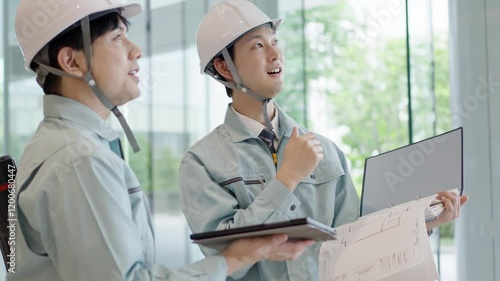 打ち合わせをする作業服を着た男性