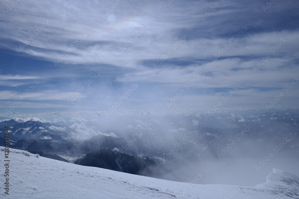 A stunning rock formation covered in snow, set against a clear blue sky with fluffy clouds in the background, creating a peaceful and breathtaking mountain landscape. A stunning rock formation covered in snow, set against a clear blue sky with fluffy clouds in the background, creating a peaceful and breathtaking mountain landscape.