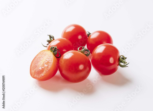 Obraz na plátně Close up of a half-cut raw cherry tomato with red fruit and stalk close to whole