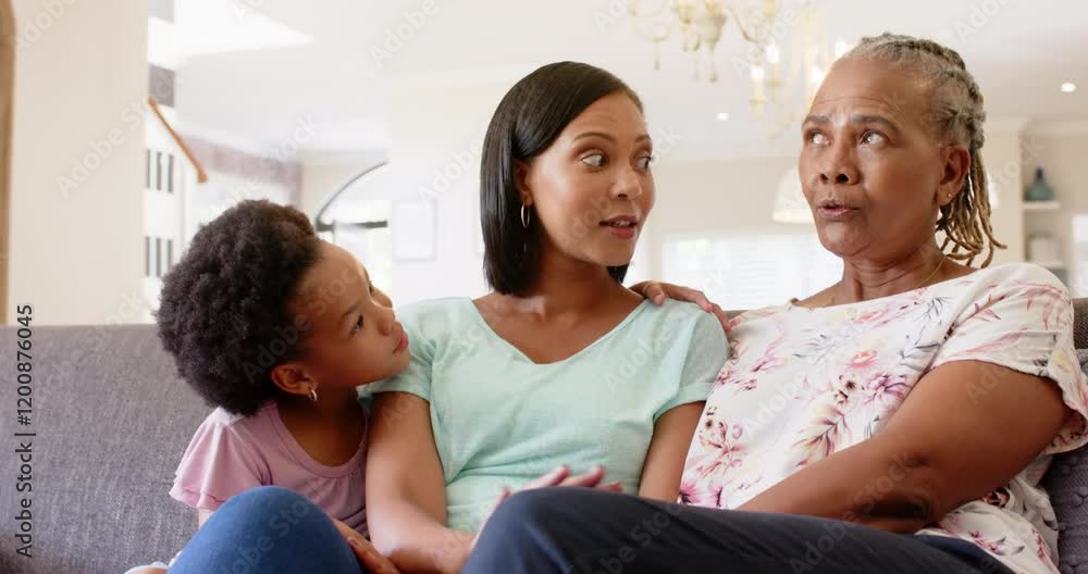 Three generations of african american women sitting on couch, talking and bonding at home Three generations of african american women sitting on couch, talking and bonding at home