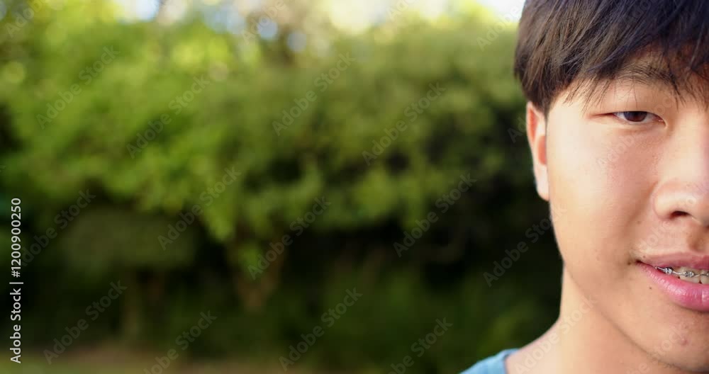 Smiling boy with braces enjoying outdoor time in green garden setting, copy space Smiling boy with braces enjoying outdoor time in green garden setting, copy space