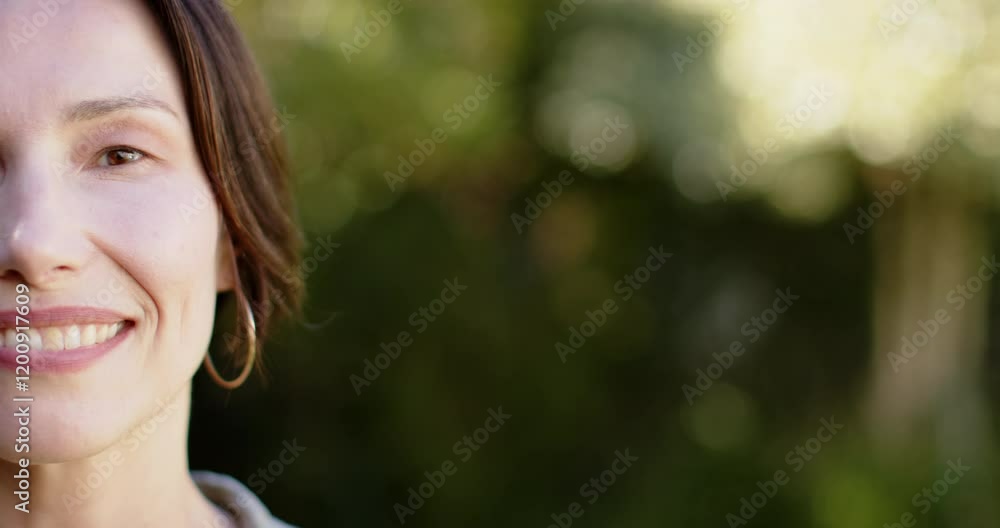 Smiling woman with short hair wearing hoop earring outdoors in natural light, copy space Smiling woman with short hair wearing hoop earring outdoors in natural light, copy space