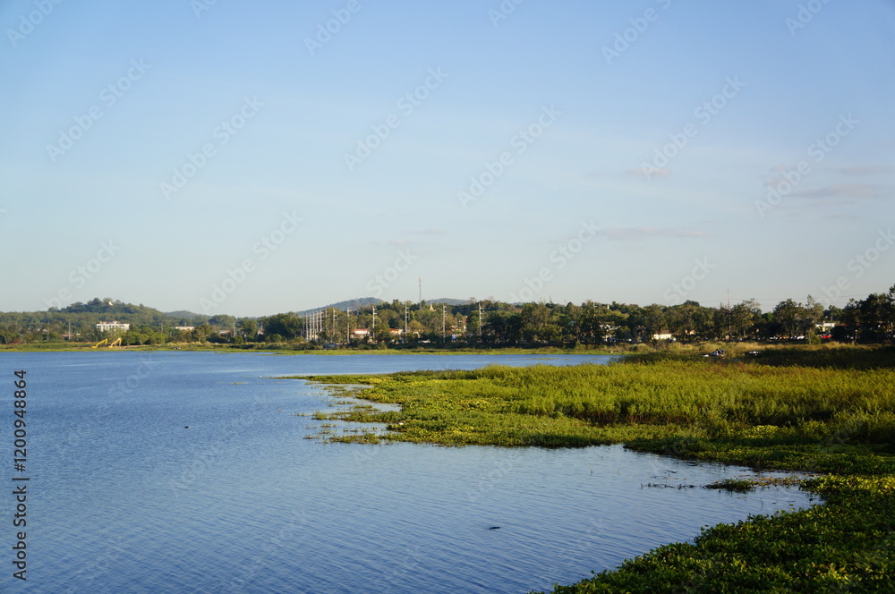 Serene Lake Landscape with Green Vegetation and Calm Blue Waters Serene Lake Landscape with Green Vegetation and Calm Blue Waters
