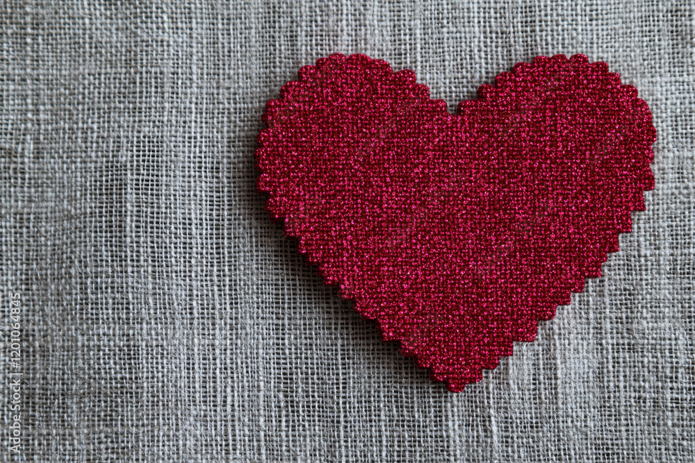 Red glitter heart on textured gray fabric background, symbolizing love and warmth Red glitter heart on textured gray fabric background, symbolizing love and warmth