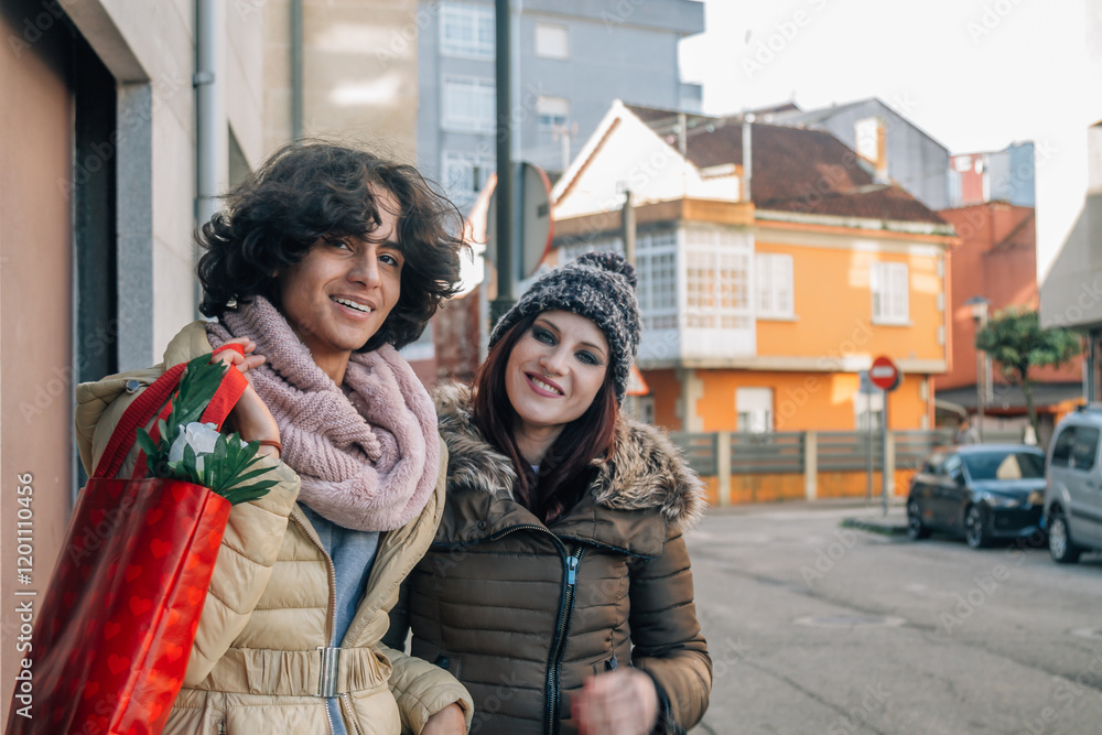 Obraz premium Multiracial couple very much in love embracing celebrating Valentine's Day, walking down a street