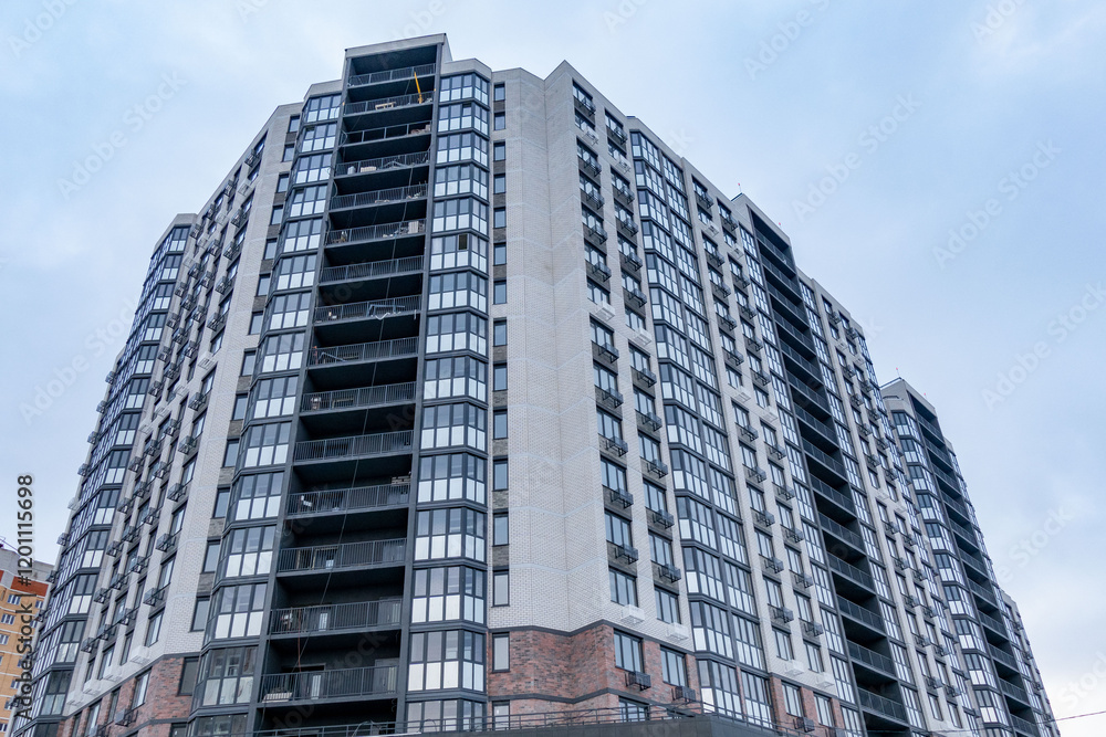 A large building with many windows and a grey brick facade A large building with many windows and a grey brick facade