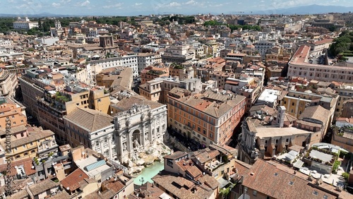 La fontana di Trevi a Roma, gremita di turisti, vista dall'alto.
Ripresa aerea con drone della Fontana di Trevi piena di visitatori in una giornata estiva. photo