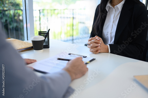 Fotografie Candidate in formal wears attentively sitting across from an interviewer reviewi