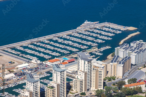 Gibraltar, British Overseas Territory and city on the Iberian Peninsula. Luxury marina with yachts and modern high-rise buildings. A stunning coastal view.