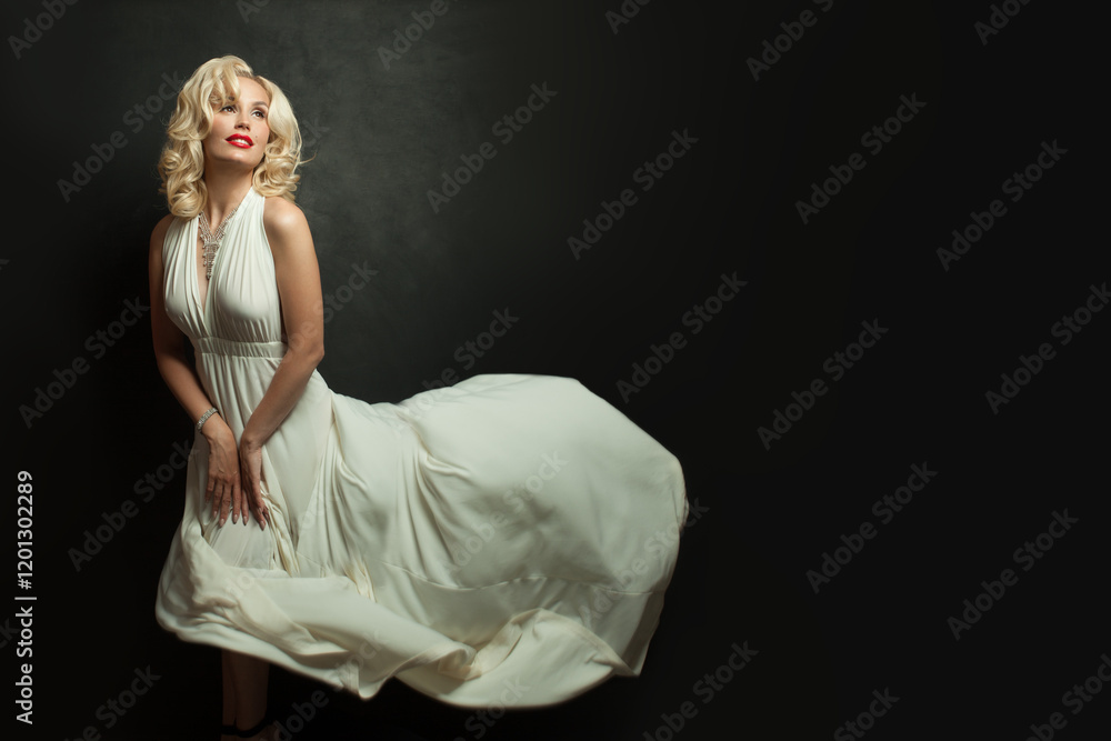 Glamorous woman with blonde hair in white silky dress on black background. Beautiful blond lady with make-up and wavy hairstyle Glamorous woman with blonde hair in white silky dress on black background. Beautiful blond lady with make-up and wavy hairstyle