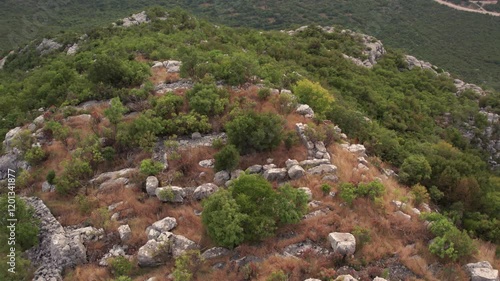 Orbiting drone shot of ruins of ancient building on top of a mountain photo