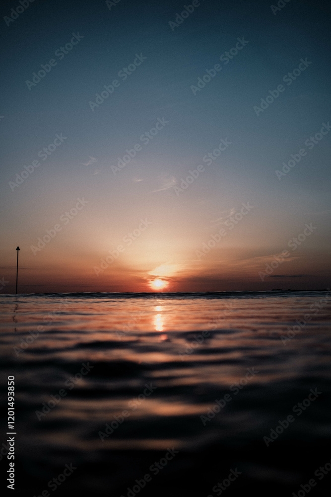 The sky is a deep blue color with a bright orange sun in the background The sky is a deep blue color with a bright orange sun in the background