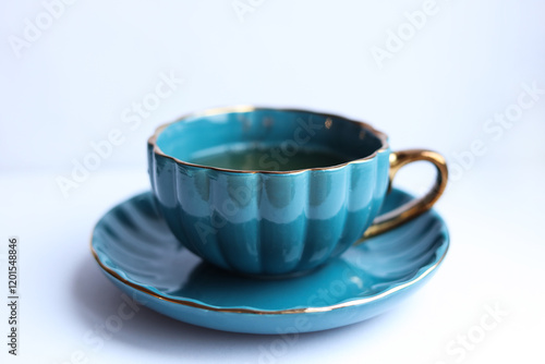 Blue cup of tea with saucer on a white background.