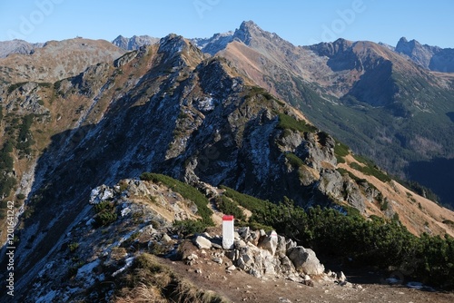 Scenery of autumn Tatras Mountains with white and red border post Poland Slovakia. Czerwone Wierchy range from around Kasprowy Wierch Peak, Tatras Mountains, Poland.  
