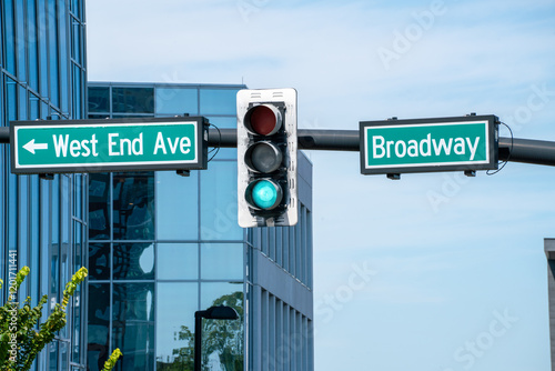 A traffic light at a busy intersection indicates green as vehicles prepare to turn onto West End Avenue or proceed on Broadway during daylight hours in Nashville, Tennessee.
