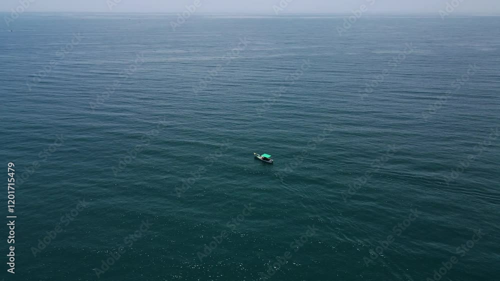 Aerial drone shot focusing on a fishing boat dwarfed by the vast and boundless ocean around it. Aerial drone shot focusing on a fishing boat dwarfed by the vast and boundless ocean around it.