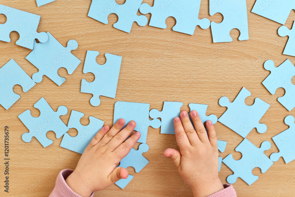 custom made wallpaper toronto digitalhands of little child arranging blue puzzle on wooden desk, top view, Education concept.