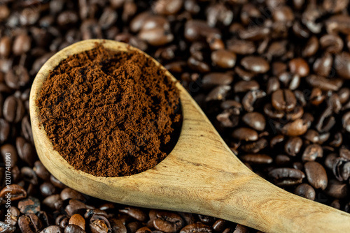 Wood spoon with coffee grounds on coffee beans  photo