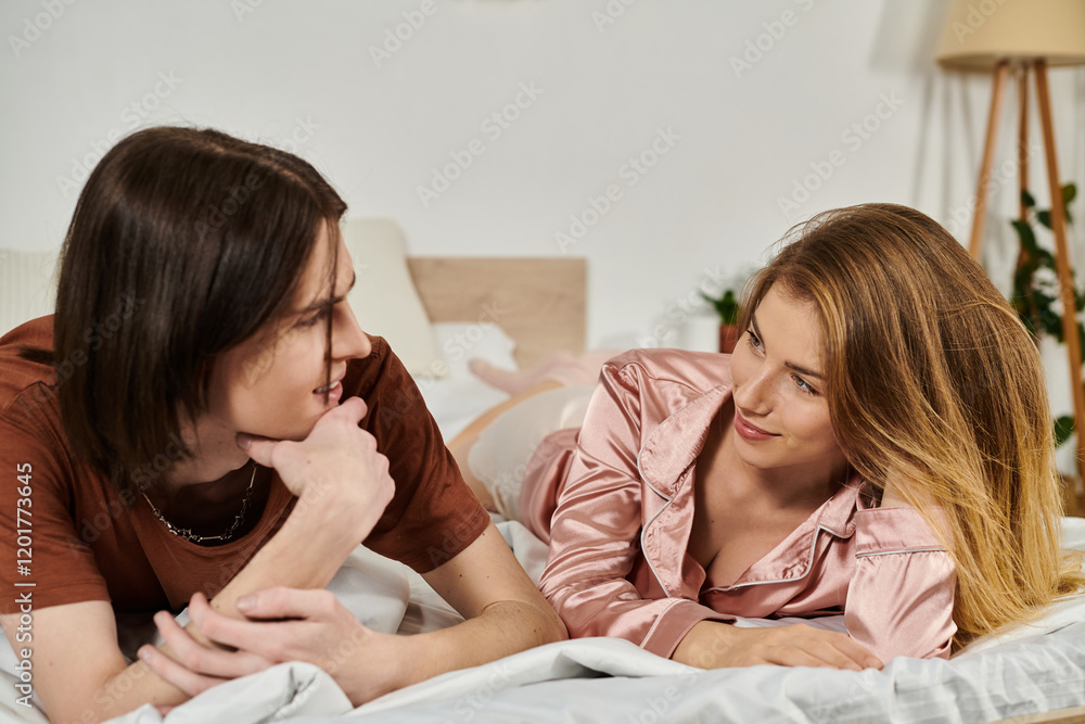 Young pair relax and connect in their trendy bedroom while sharing laughter and smiles. Young pair relax and connect in their trendy bedroom while sharing laughter and smiles.