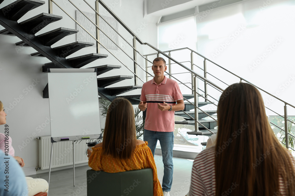 © New Africa - Male lecturer in casual clothes talking to audience indoors
