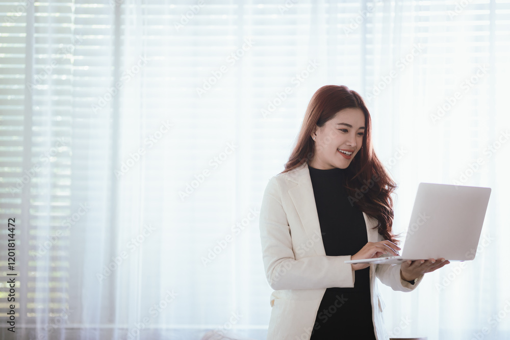 Smiling Thai Asian businesswoman working in a modern office. She is overflowing with professionalism, happiness and success in a corporate environment. Smiling Thai Asian businesswoman working in a modern office. She is overflowing with professionalism, happiness and success in a corporate environment.