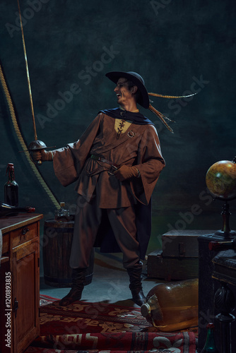 Lively pirate captain laughing confidently while looking at rapier against dark background with vintage maritime props. Brave traveler, marine lifestyle, Concept of adventures, history photo